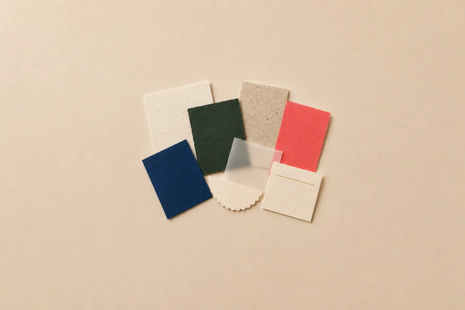 Top-down arrangement of specialty paper samples with embossed, linen, vellum, recycled, coloured, and foil finishes